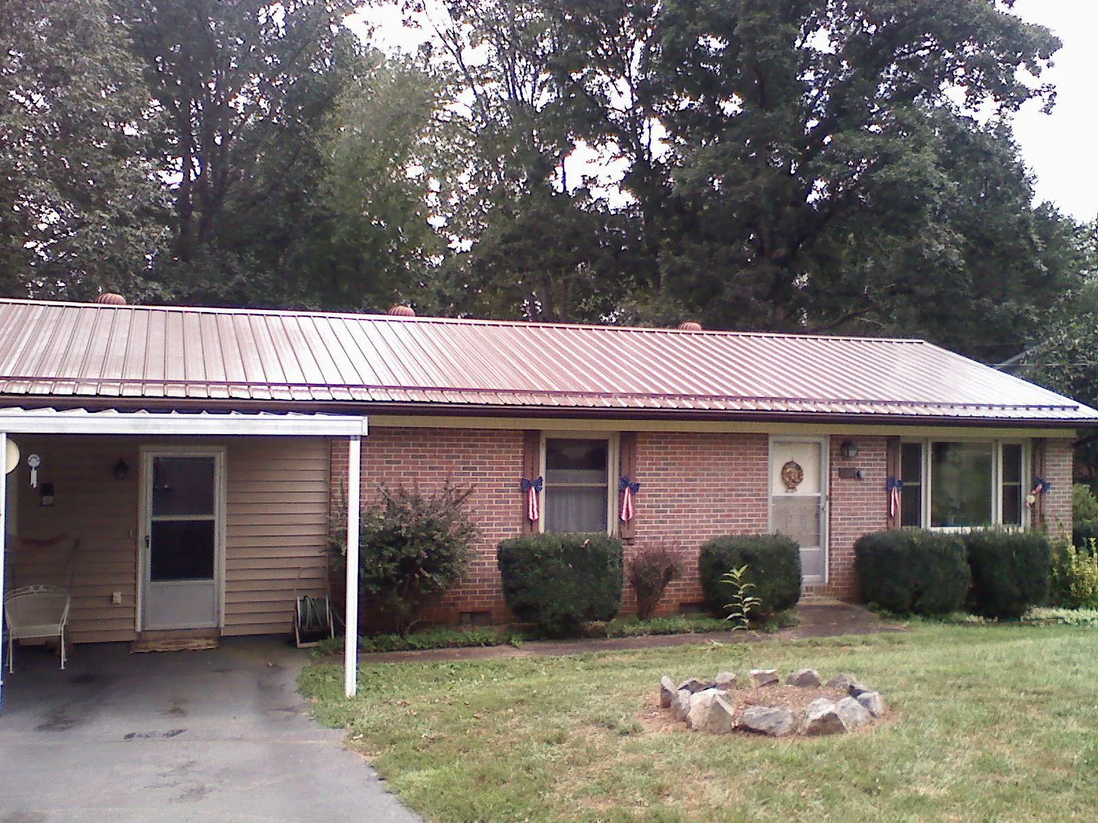Bronze metal roof and carport on a brick ranch home — Roof Repair work by our crew in Luke